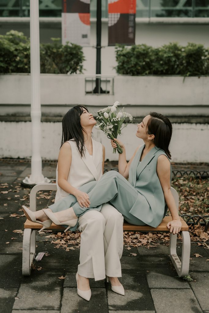 結婚登記攝影 板橋戶政登記後 拍攝生活婚紗兩人穿搭同色服裝風格 兩人坐在
木椅上開心聊天 丰FENG