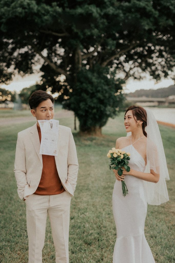 結婚登記攝影信義戶政登記後到戶外的公園新郎俏皮咬著書約拍攝生活婚紗丰FENG