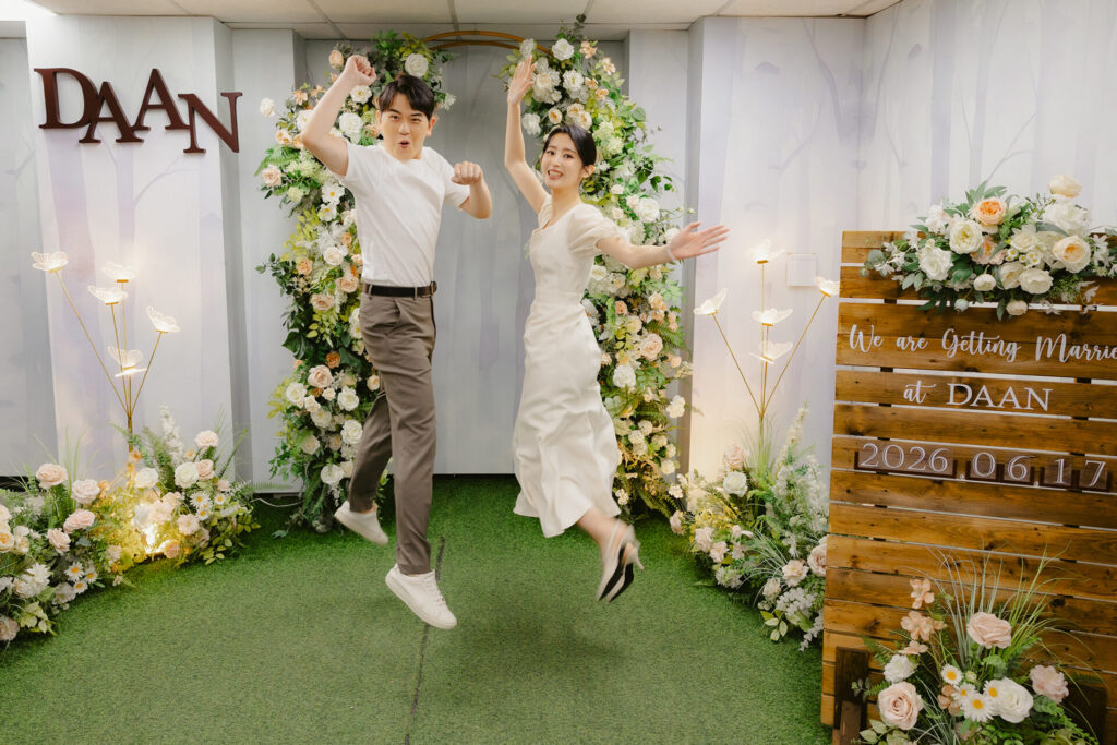 2026台北大安戶政事務所結婚登記攝影，新人在花牆前開心跳躍合照